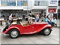 SJ9494 : Red car and secondhand bookstall outside Clarendon Square Mall by Gerald England