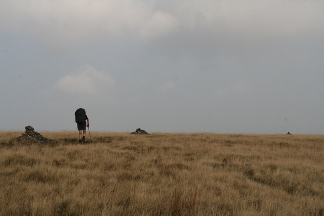 Three cairns and a hiker on the Pennine Way north of the Black Hill trig point
