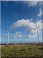 SS9591 : Transmitter mast (with stabilising wires) and wind turbines on Mynydd Maes-teg by Gareth James