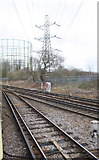 TQ2266 : Electricity pylon and gas holders at railway junction by Roger Templeman