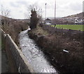 Afon Llynfi flows past a football ground in Caerau