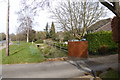 Grass verge and housing on Effingham Common Road