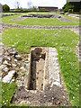 Looking west across ruins at Muchelney with tomb in foreground