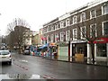 TQ3082 : Shops, wet Sunday morning, King's Cross Road, London by Robin Stott