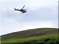NT9522 : Bracken spraying helicopter near Langleeford by Andrew Curtis