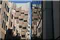 View of the London Underwriting Centre building reflected in the windows above EAT on Mark Lane