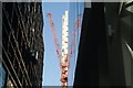 View of a construction crane reflected in 125 Old Broad Street