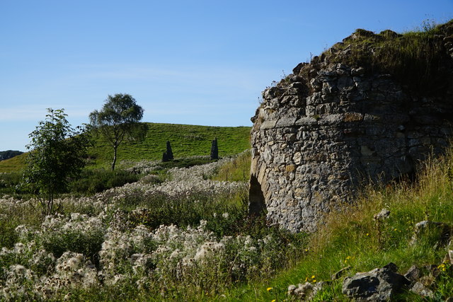 Side view of disused lime kiln looking towards derelict building