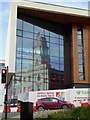 Barnsley Town Hall reflected in the glass of the new 6th form college