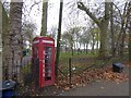 Telephone box set into the railings of Queens Park