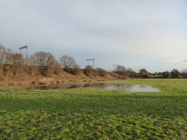 Partly flooded field alongside railway line