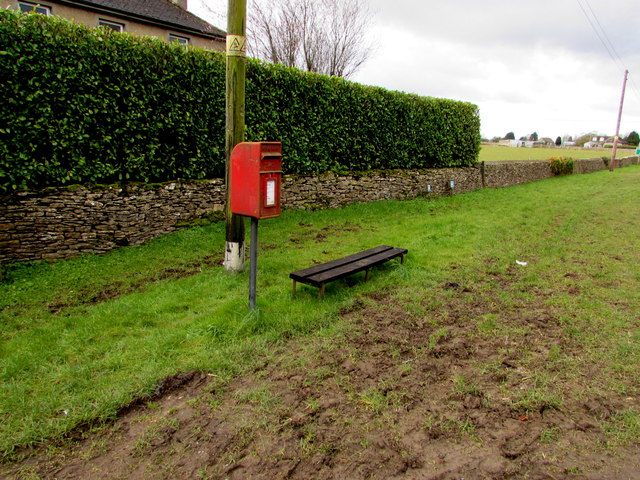 Queen Elizabeth II postbox and a low bench near Minchinhampton