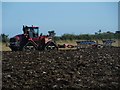 NU2403 : Ploughing east of Morwick by Graham Robson