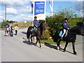 Horse riders passing entrance of new development