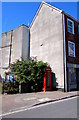 Partly hidden red phonebox in Topsham