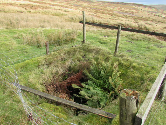 Rotten fence surrounding deep mine shaft
