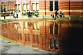 View of the Victoria and Albert Museum reflected in the water in John Madejski Garden