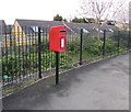 Queen Elizabeth II postbox alongside Llantarnam Road railings, Cwmbran