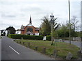 Village sign and the Church of The Brotherhood of The Cross and Star, Milespit Hill