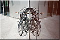 View of a pair of bikes reflected in the spike of an office block in the Paddington Basin