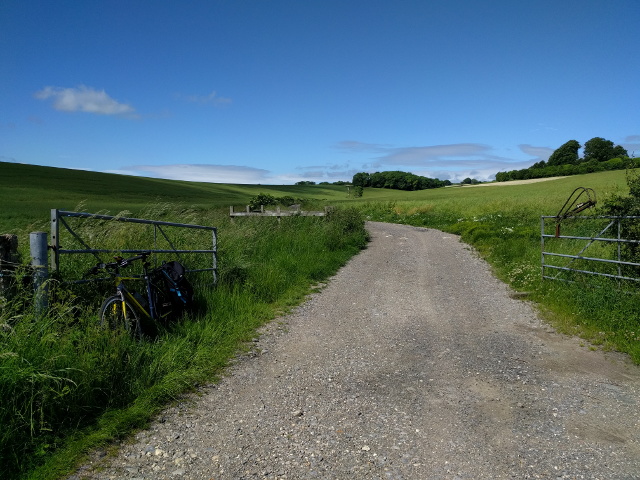 Farm track which is a public footpath, and a bike at the gate
