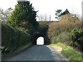 A rail bridge crosses a rural road neat Weston Colley