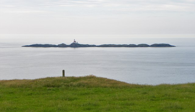 Coast path waymarker and a view to The Skerries