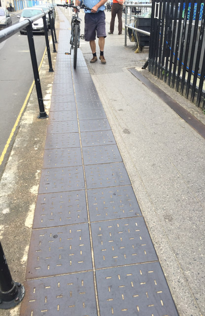 Perforated iron plates as paving along Custom House Quay, Weymouth 