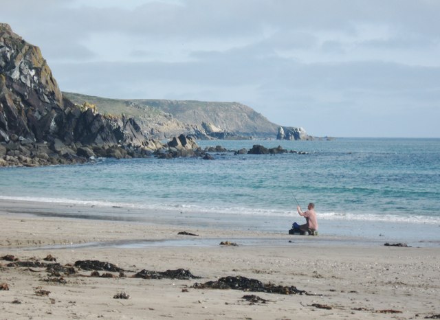 Lone sea angler on the beach at Kennack Sands Cornwall