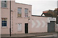 View of TATTOOS lettering and chevrons painted on the side of Menagerie Makes from Gaywood Road