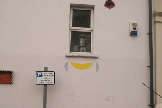 View of "smile" street art on the side of Salvage Electrical from Ruby Road
