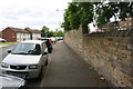 Stone wall and parked cars of Park Lane