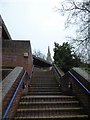 Church spire glimpsed from steps up to Sainsbury