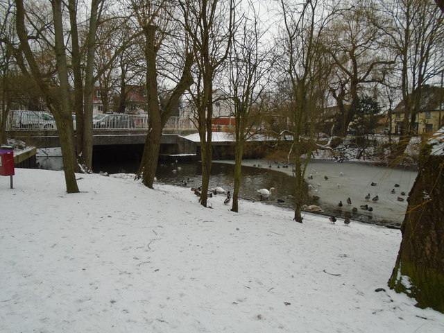 Part-frozen River Colne by road bridge to industrial Estate