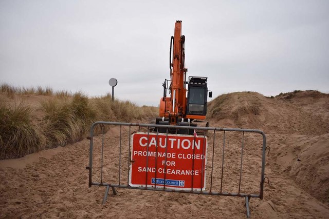 Removing sand from the promenade