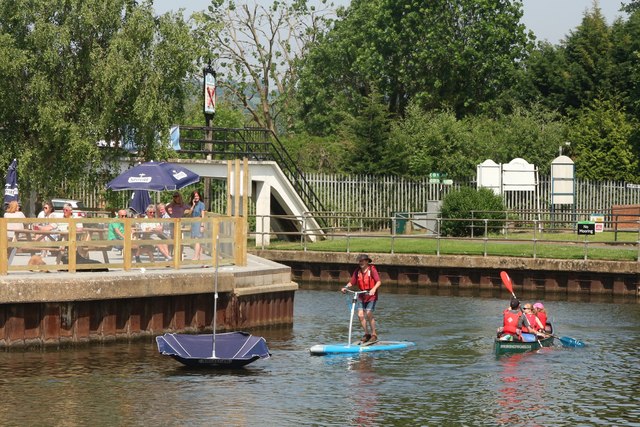 Pedal boarder and canoe by The Boathouse