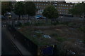 View of graffiti on the back of the hoarding around a derelict piece of land from Westferry DLR station