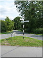 Black & white signpost on a green triangle