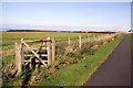 NX9826 : View over field from pavement beside Salterbeck Road by Roger Templeman
