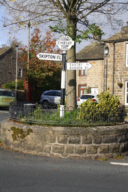 Signpost on roundabout at road junction at Elm Tree Square