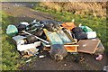 Flytipped rubbish in a field gateway