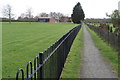 Footpath into Cheddington with an orchard on the right