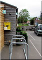 Cycle racks and yellow defibrillator box, Church Road, Oldbury-on-Severn 