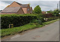 Yellow hydrant market alongside a hedge, Llangrove, Herefordshire