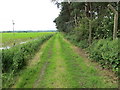 Enclosed grass track beside Thorp Arch Trading Estate  and arable field