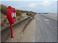 Lifebelt on the promenade at Ffrith Beach