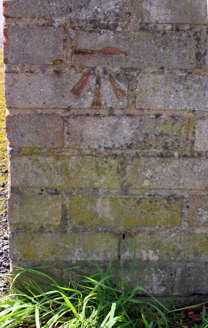 Benchmark on garage block on SW side of Fotheringhay Road