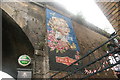 View of street art advertising The Charlotte public house on the railway arch on Union Street