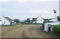 J3316 : Bungalows, hay field and wind turbine East of Pat's Road Kilkeel by Eric Jones