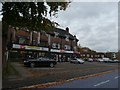 Row of shops at junction of Bristol Road and Wellington Road